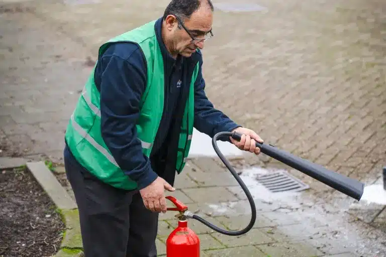 Trainer bedient een brandblusser